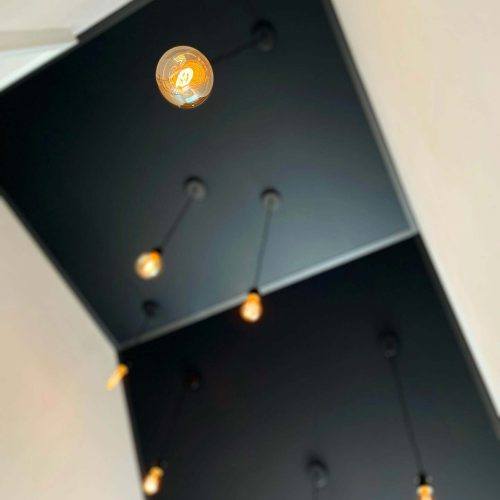 Filament LED-Leuchten mit Textilkabel passend zur schwarz-matten Decke im Treppenhaus